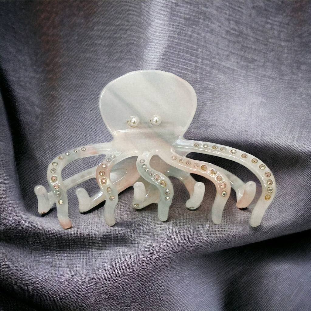 Pearl and rhinestone embellished octopus-shaped hair clip in iridescent white for a touch of under-the-sea glam.
