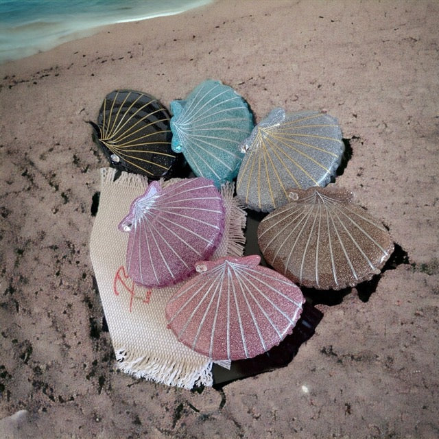 glitter shells of different colors on a beach