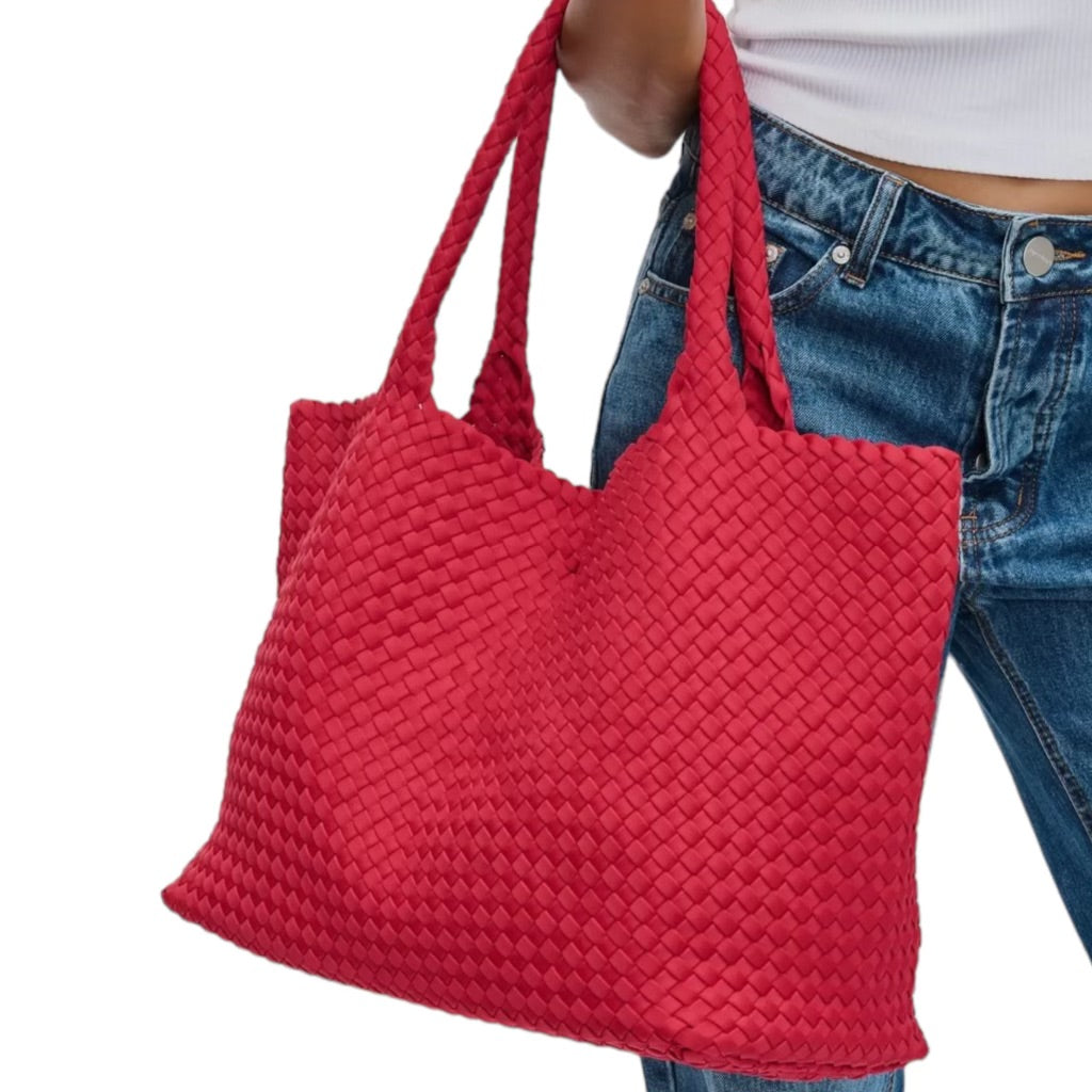 Spacious red tote with a basketweave pattern, offering plenty of room for belongings, ideal for beach days or picnics.