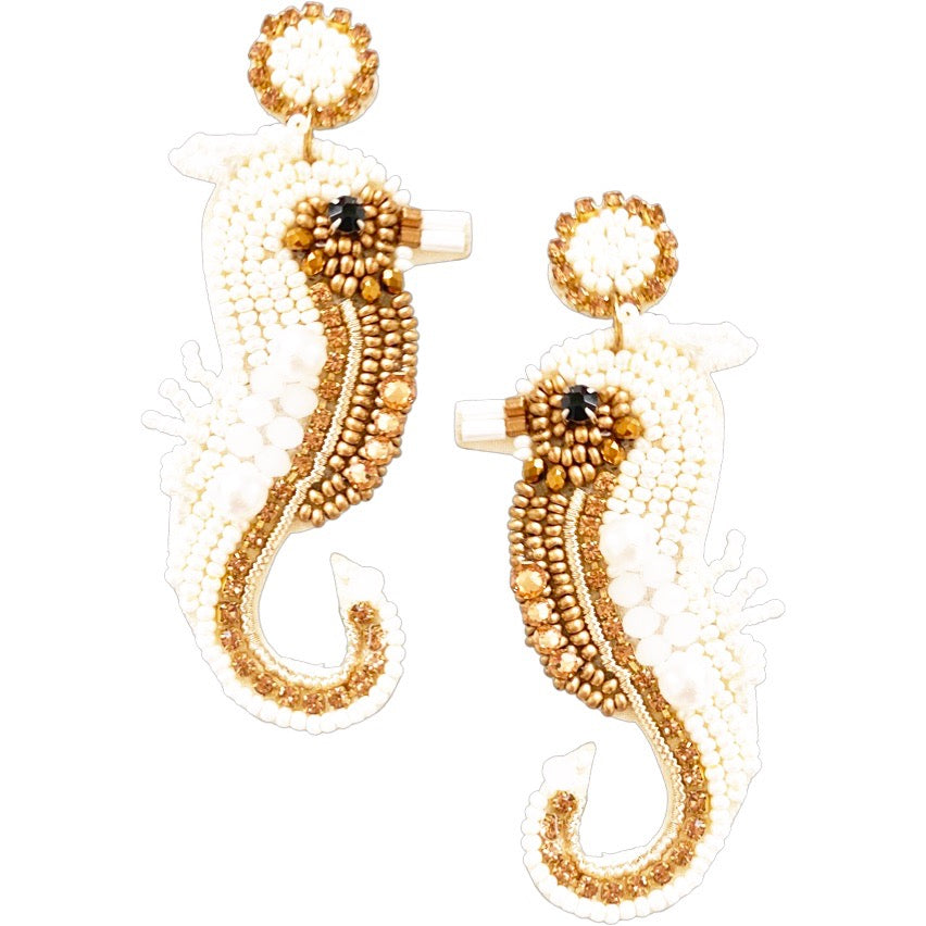 Elegant seahorse earrings adorned with white and gold beading, a unique accessory for ocean lovers.