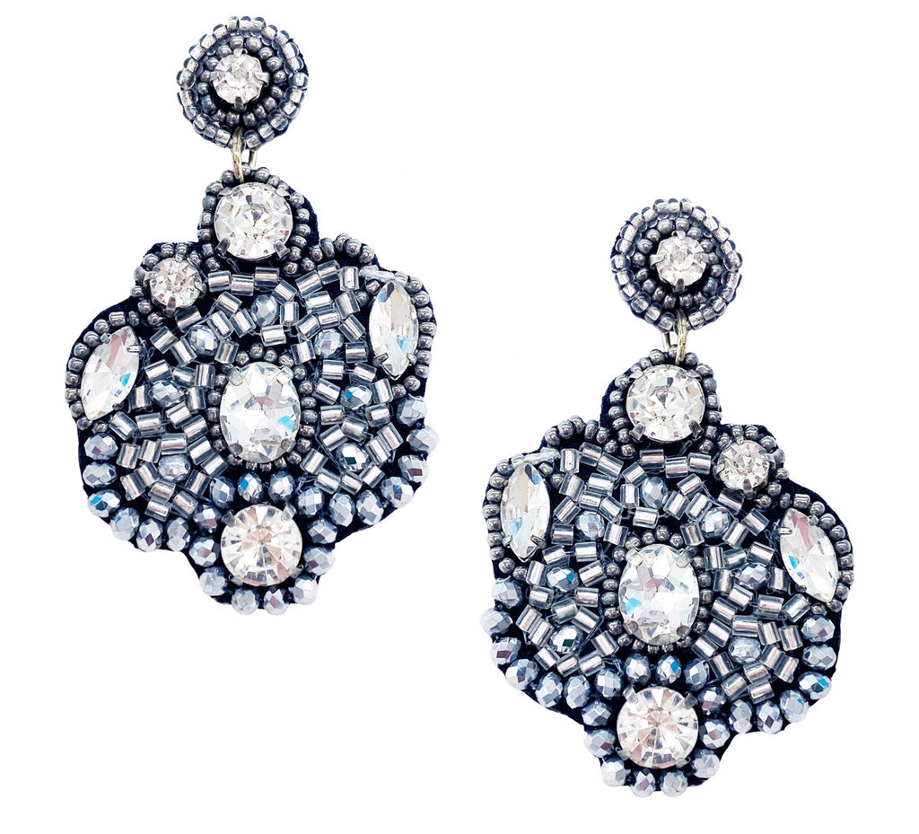 Shimmering silver earrings featuring a bold, statement design with a playful bear patch, ideal for evening wear.