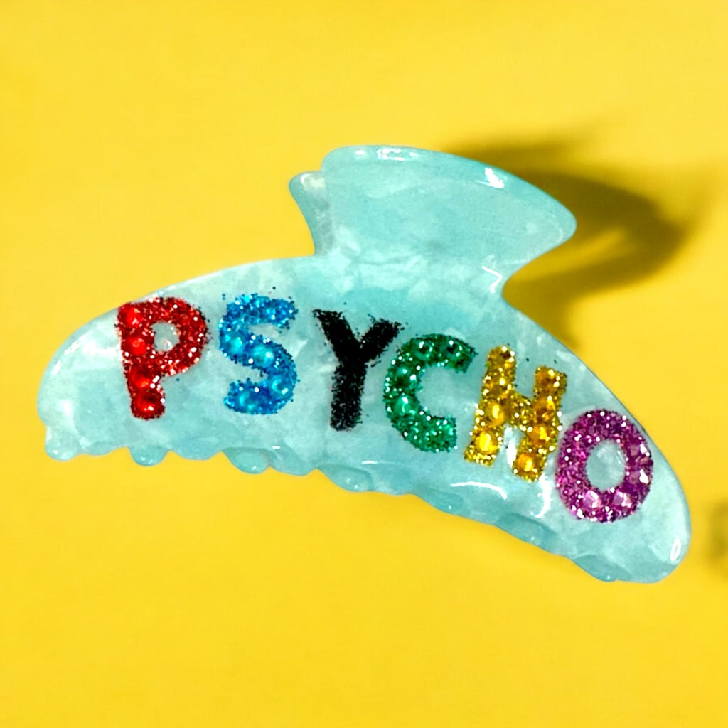 Fun blue marble hair clip with colorful glitter letters spelling "Psycho," ideal for thick hair.