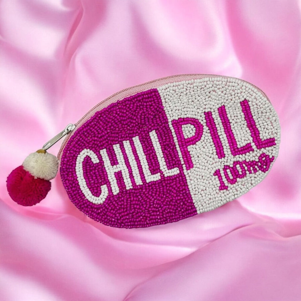 Pink chill pill cosmetic pouch on a satin background