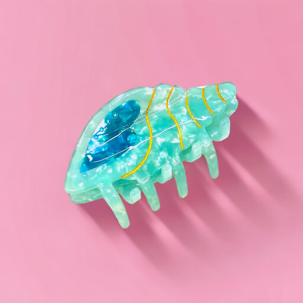 Aqua conch hair clip with gold accents, perfect for beachy and tropical looks.