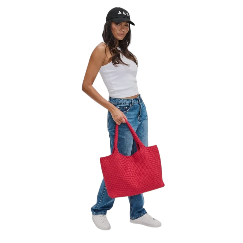 Fashionable red tote bag with a distinctive basketweave design, perfect for adding a chic touch to any outfit.