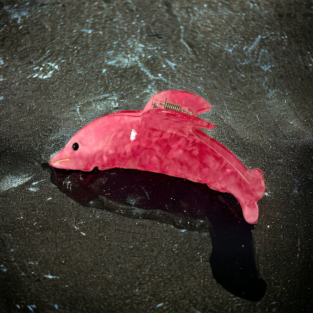 Cute dolphin-shaped hair clip in a lively pink hue, perfect for a fun and fashionable look.