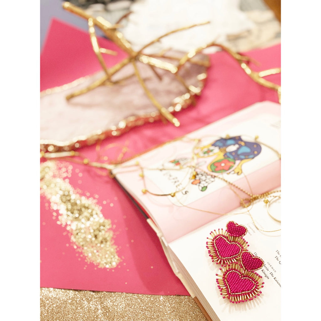 Eye-catching pink and gold statement earrings with a unique double heart shape and a fun "Happy Leaves" patch.