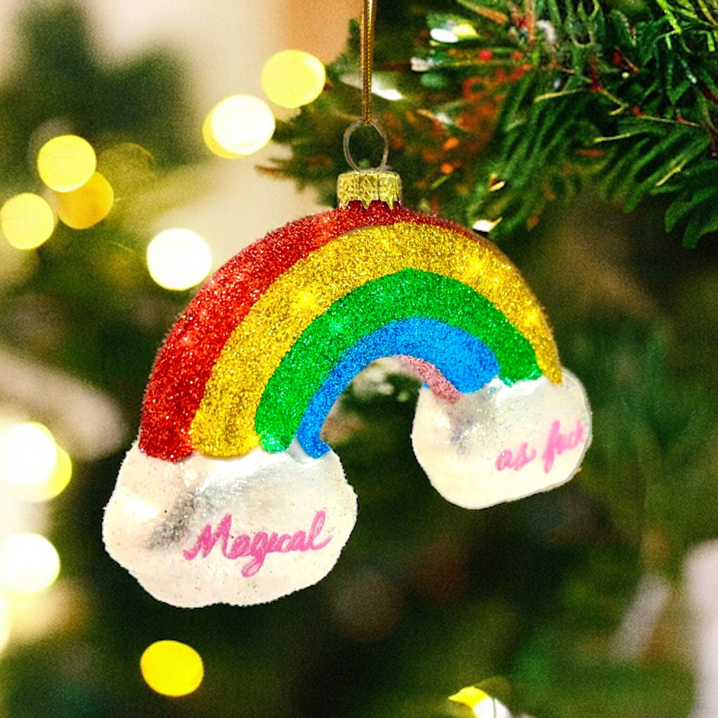 Holiday ornament with glitter rainbow and clouds that reads "Magical as f***," bringing humor and style to your tree.