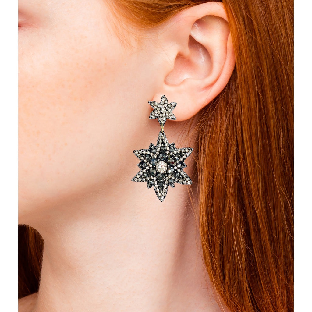 Silver earrings with star shapes and hand-set accents, designed for a chic and sophisticated look.