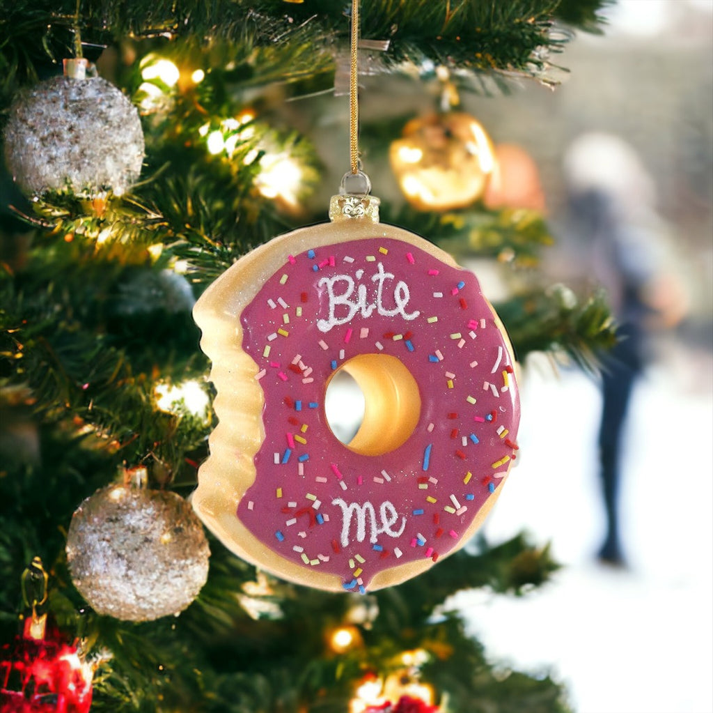 Holiday ornament shaped like a pink donut with sprinkles and a cheeky "Bite Me" message, perfect for quirky tree decor.