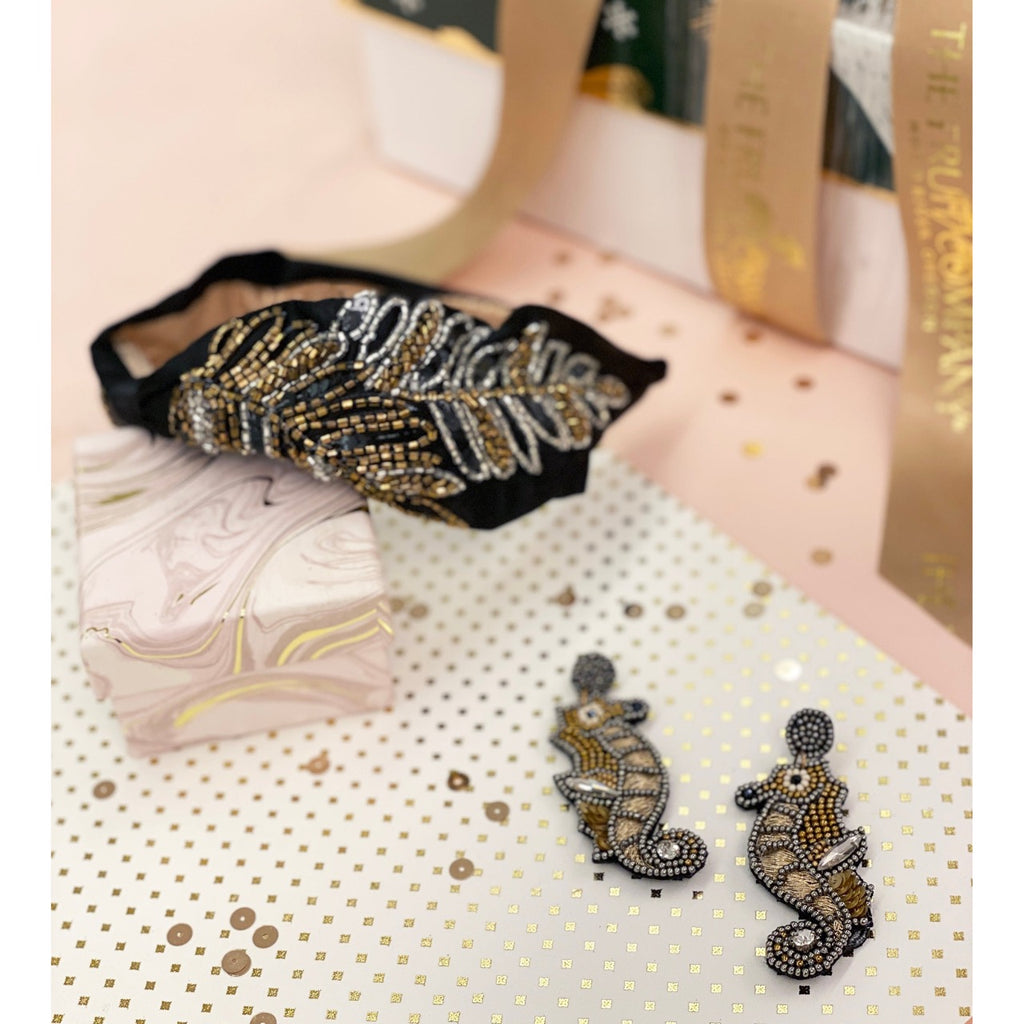 Artistic seahorse earrings with bronze and gold details, featuring intricate beadwork and a fun twist.