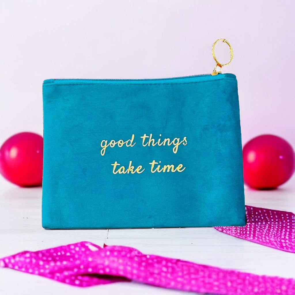 Soft and luxurious suede pouch adorned with the empowering message "Good things take time" in shimmering gold, inspiring patience and perseverance.