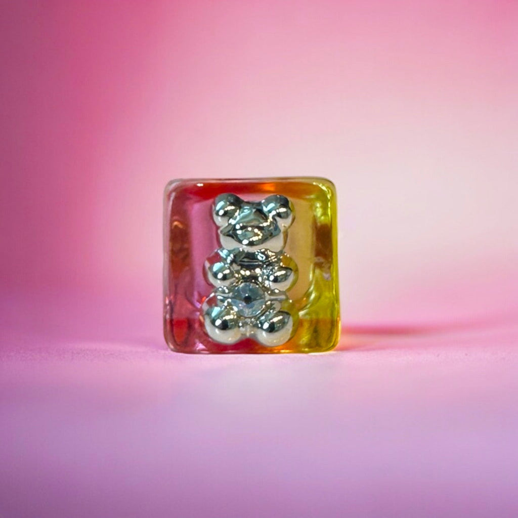 Pink gummy bear ring with a gold band, perfect for a fun and playful look.

