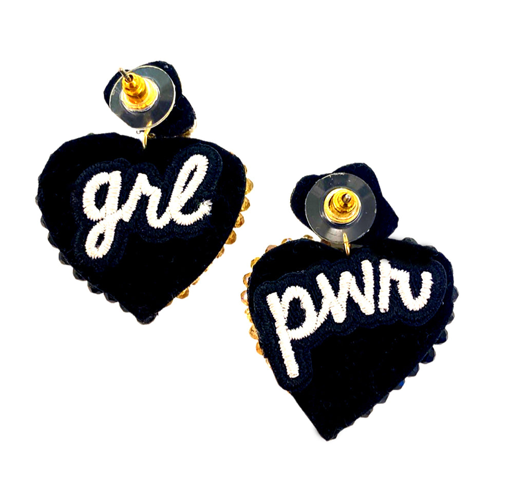 Statement earrings with heart design and "Grl Pwr" patch, blending glamour and strength.