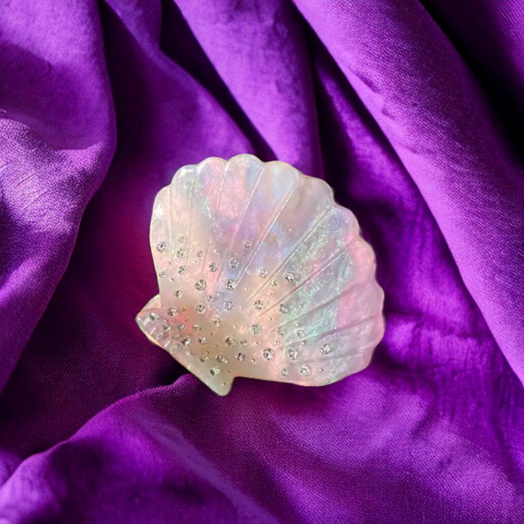 Iridescent pink shell hair clip, perfect for adding a touch of ocean-inspired sparkle to any hairstyle.