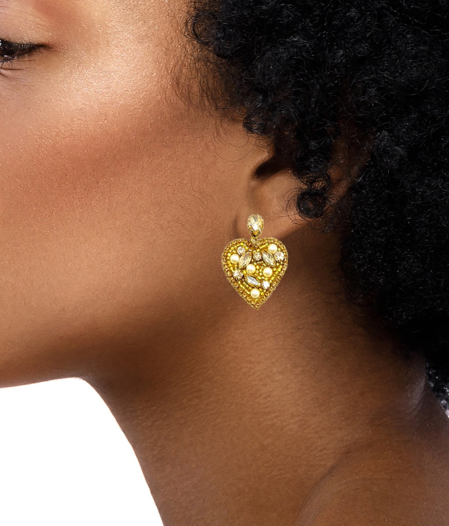 Gold earrings featuring a striking heart design, radiant stones, and an iconic Lady Liberty patch, light and comfortable.