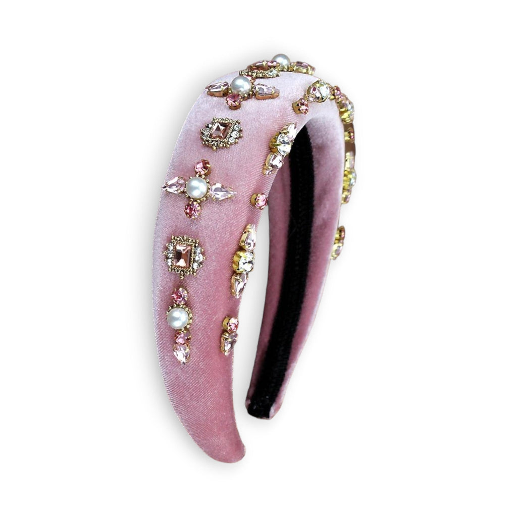 Pink velvet headband standing up with pearls in a design with rhinestones.