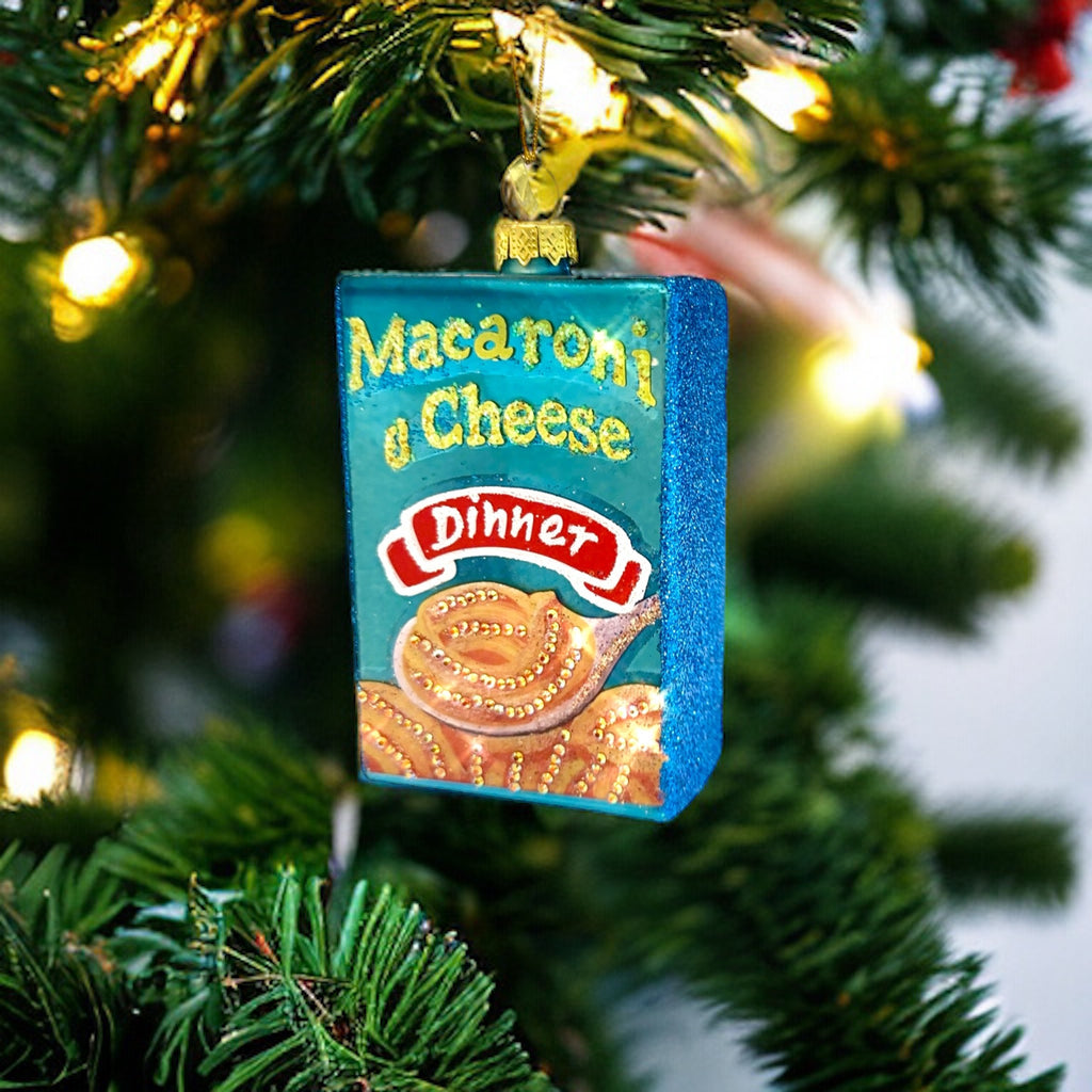 Fun and quirky glass Christmas ornament shaped like a mac and cheese box, ideal for food lovers' holiday decorations.