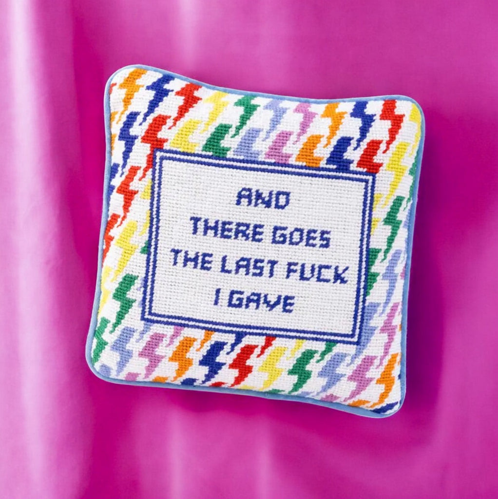 Unique needlepoint pillow with a humorous quote and colorful houndstooth design, ideal for home decor.