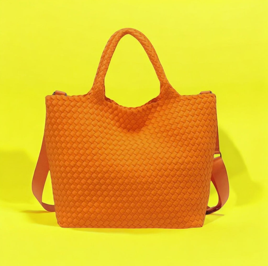 Orange tote with distinctive basketweave design, made from durable neoprene, perfect for adding a playful touch to any outfit.