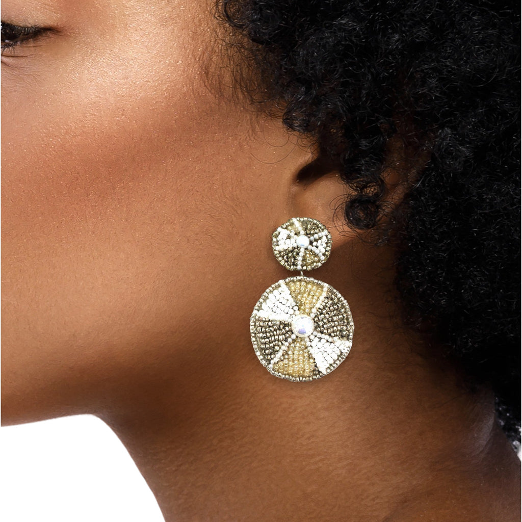 Circular dangly earrings are worn by a black model.