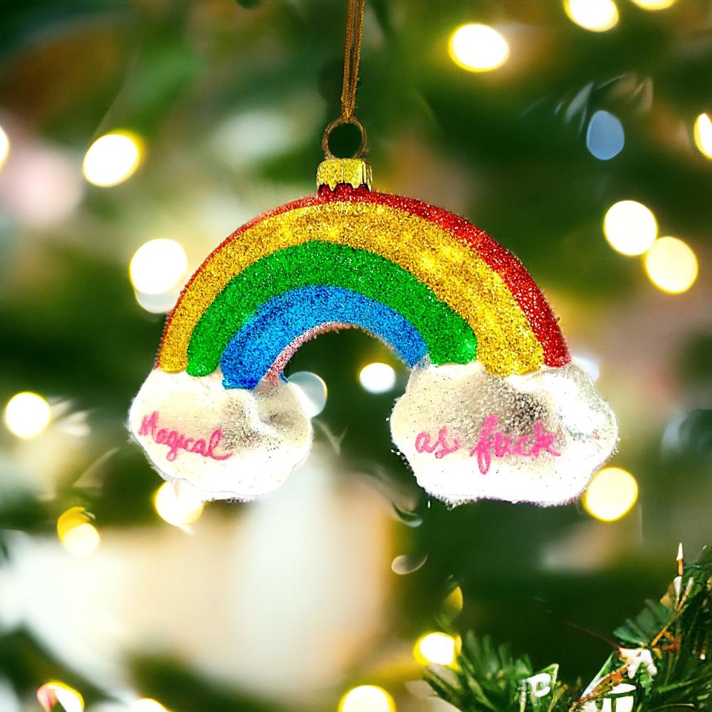 Glittery rainbow holiday ornament with the bold phrase "Magical as f***" on clouds, adding personality to your festive decor.