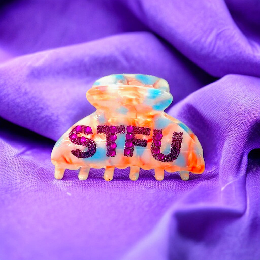 Glamorous hair clip featuring a bold "STFU" statement in shimmering crystals for a fierce and eye-catching accessory.