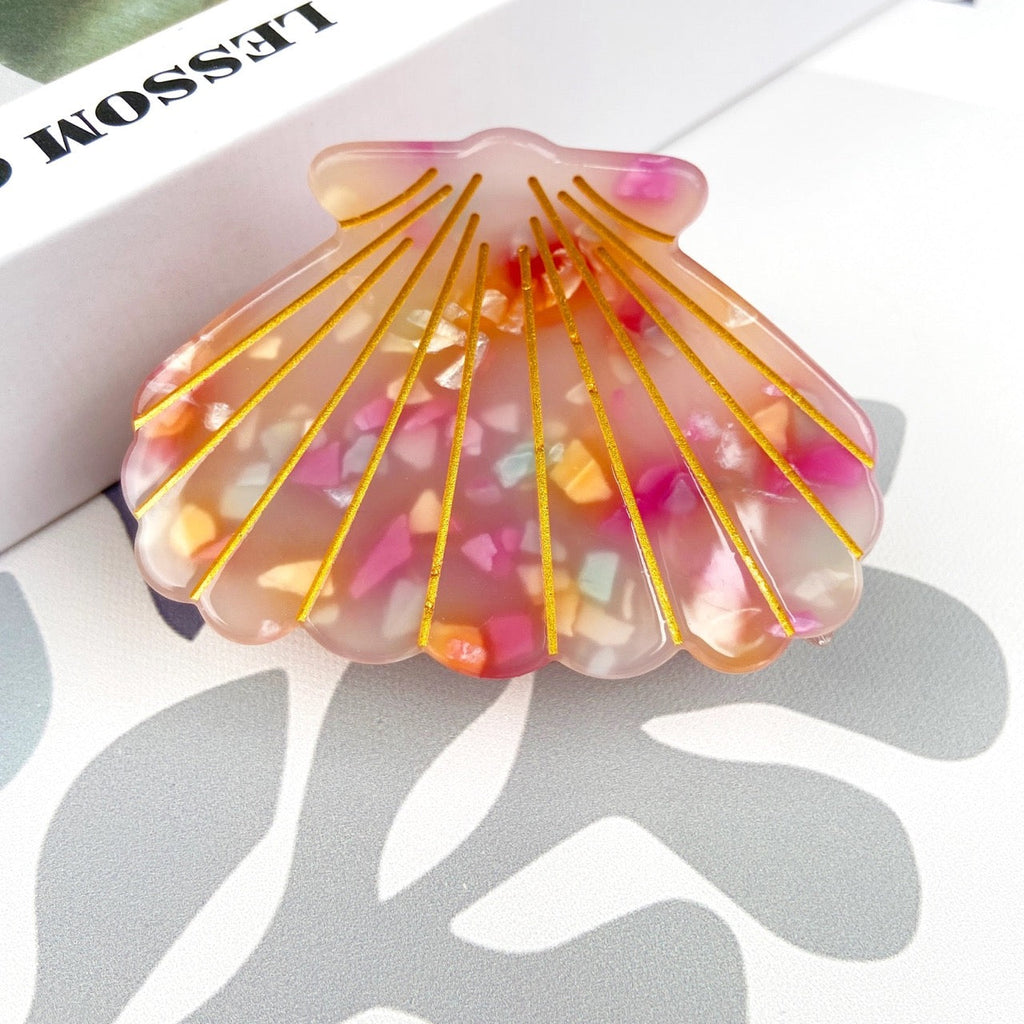 Handcrafted colorful shell hair clip on table.