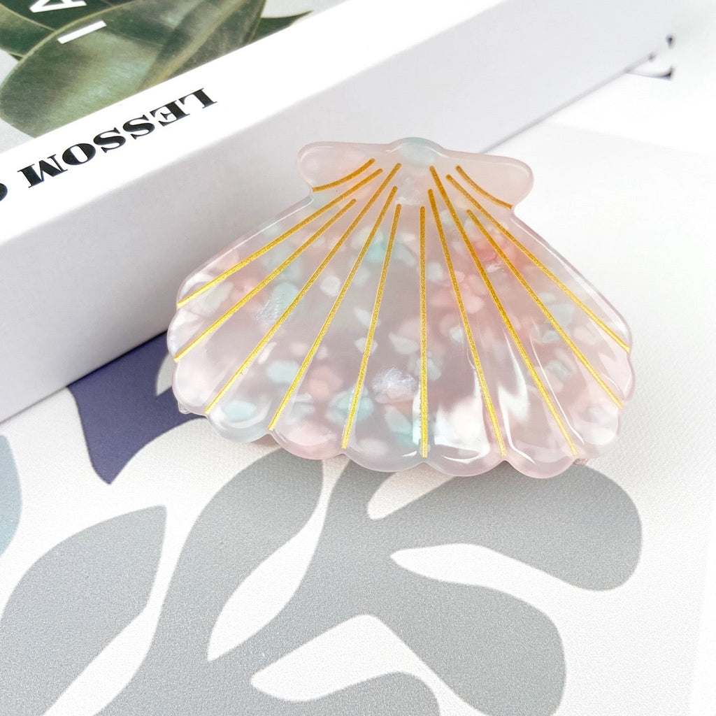 Iridescent pink shell hair clip with gold accents.