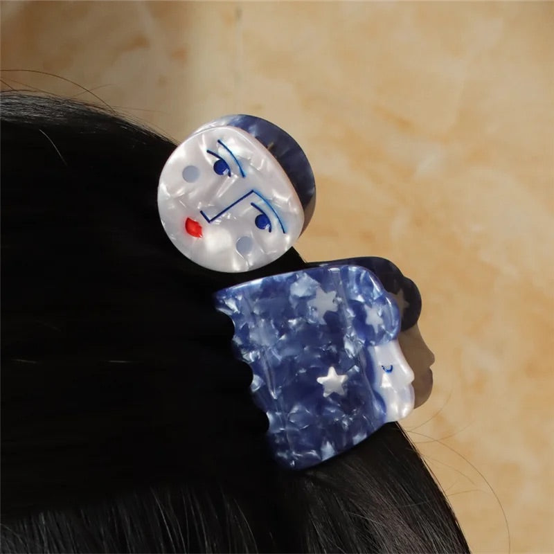 Celestial hair clip featuring a sleeping moon motif and night sky colors.