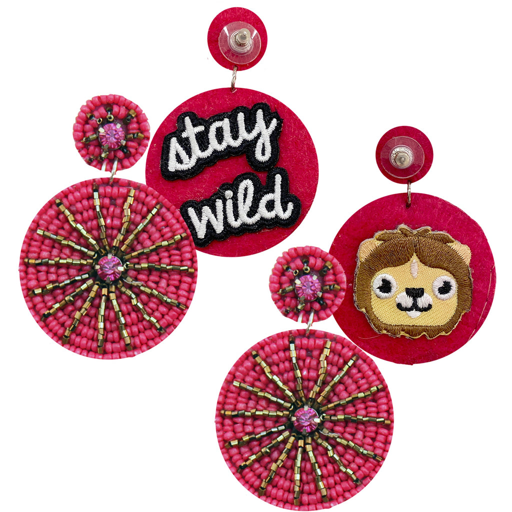 Bold fuchsia statement earrings with a starburst design, featuring "Stay Wild" and lion patches.