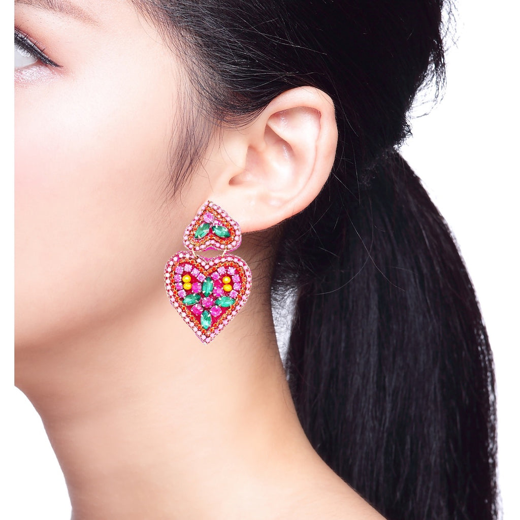 Bright pink heart-shaped earrings with colorful beaded details, perfect for bold fashion statements.