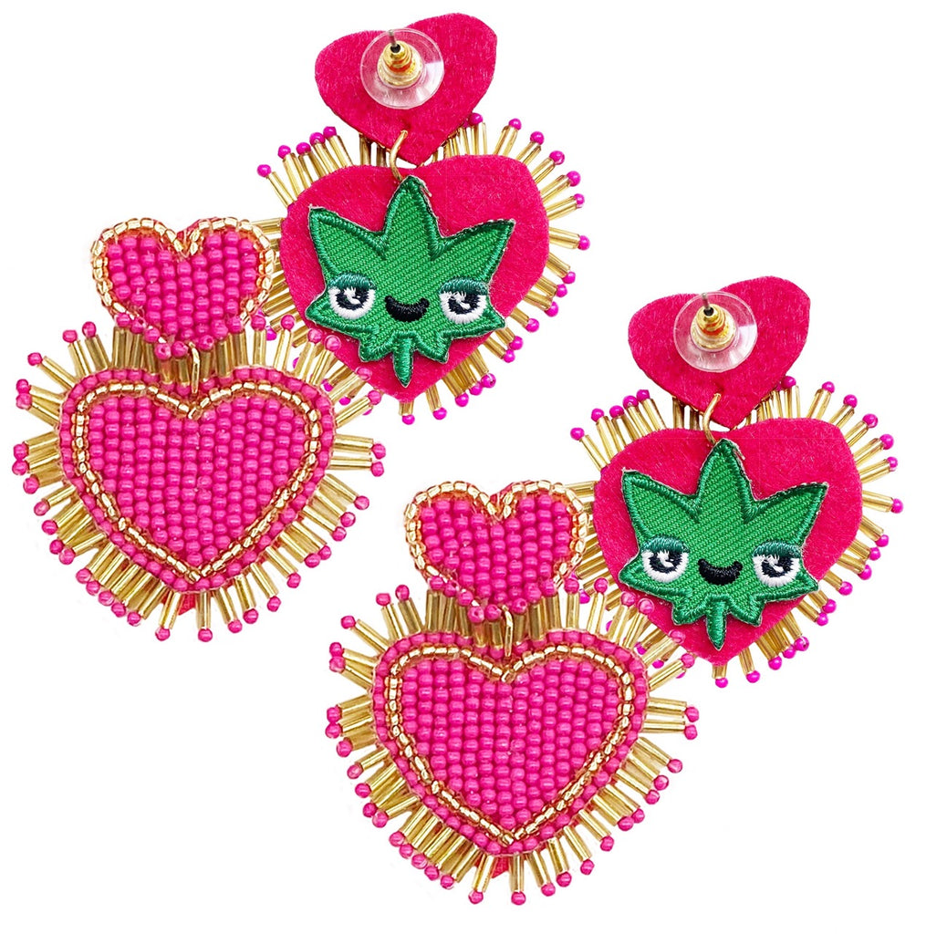 Double heart-shaped fuchsia earrings with gold fringes and a playful "Happy Leaves" patch design, perfect for bold and fun fashion statements.