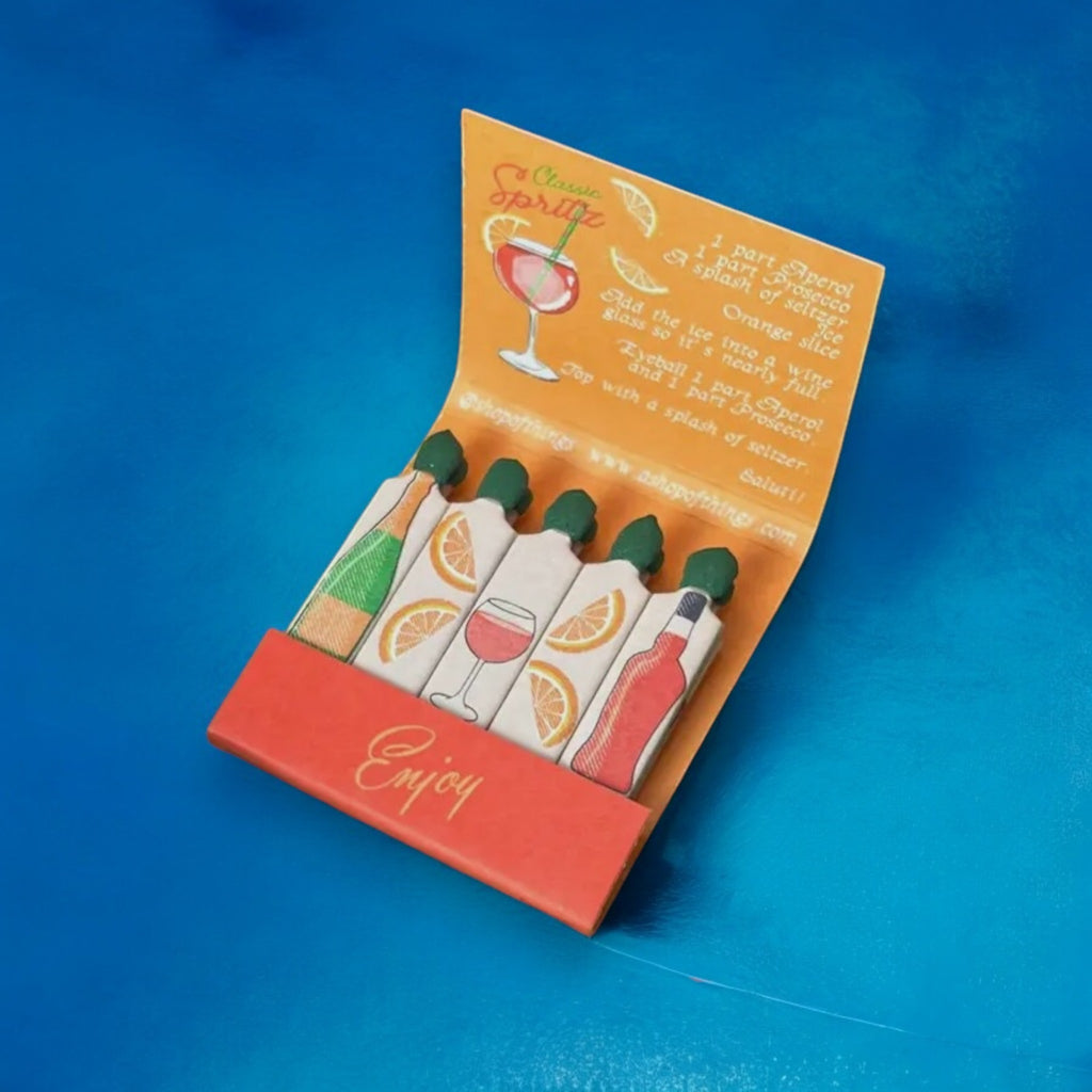 Aperol-themed matches in a bold matchbook, a perfect gift for cocktail lovers.