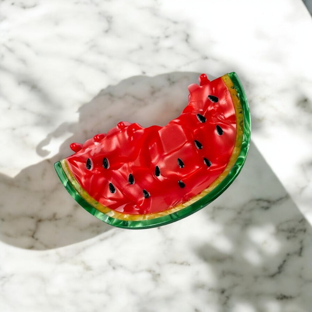 Colorful watermelon-shaped hair clip on a white background.