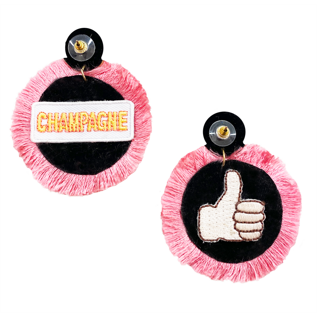 Playful pink fringe earrings with champagne and thumbs-up patch designs, hand-crafted and hypoallergenic.